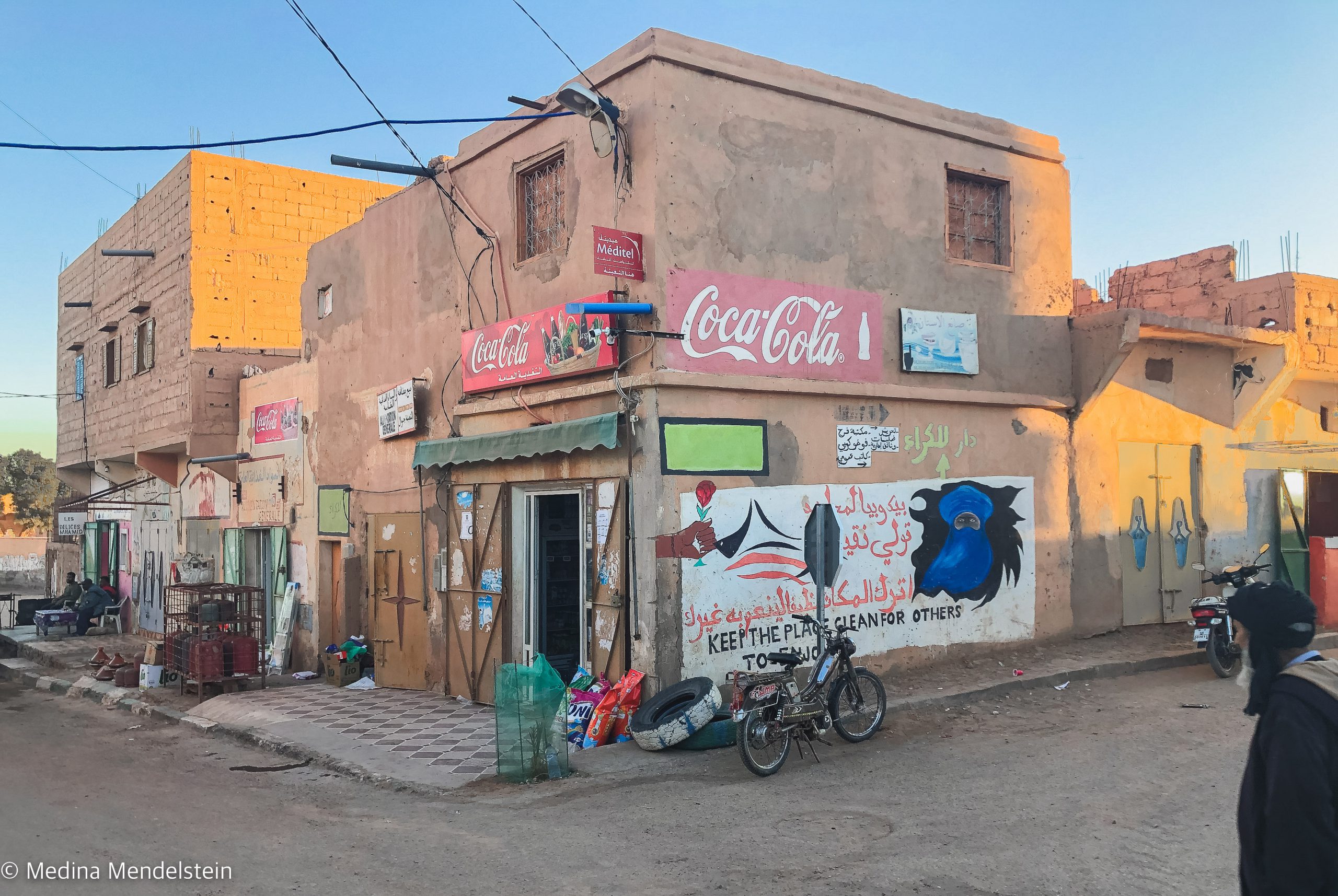 Kleinstadt in Marokko, Afrika: Ein Haus an einer Straßenecke mit Werbeaufschriften.