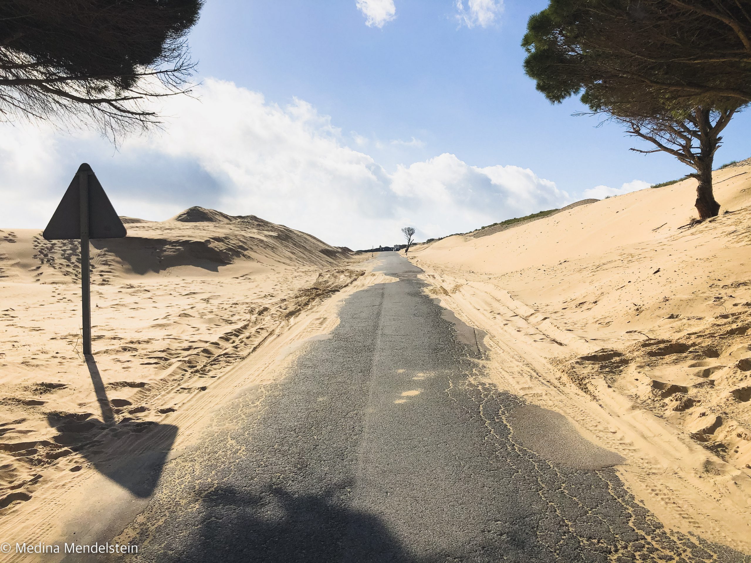 Fotografie aus Marokko, Afrika: Eine Straße, an beiden Seiten der Straße sind Sanddünen.