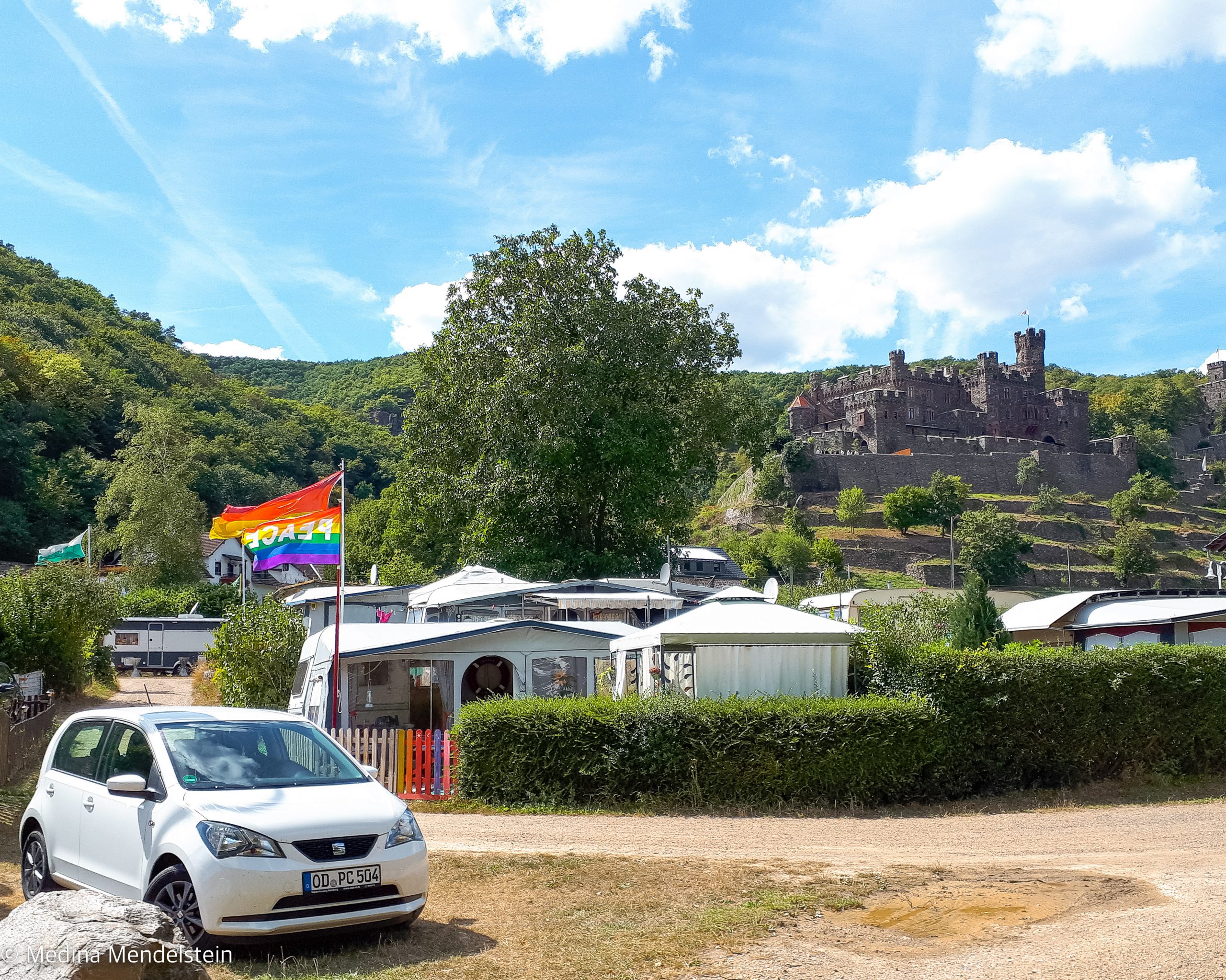 Campingplatz am Morgenbach, Trechtingshausen: Der Wohnwagen auf einem Dauercampingstellplatz von Medina Mendelstein, im Hintergrund ist eine Burg auf dem Weinberg.