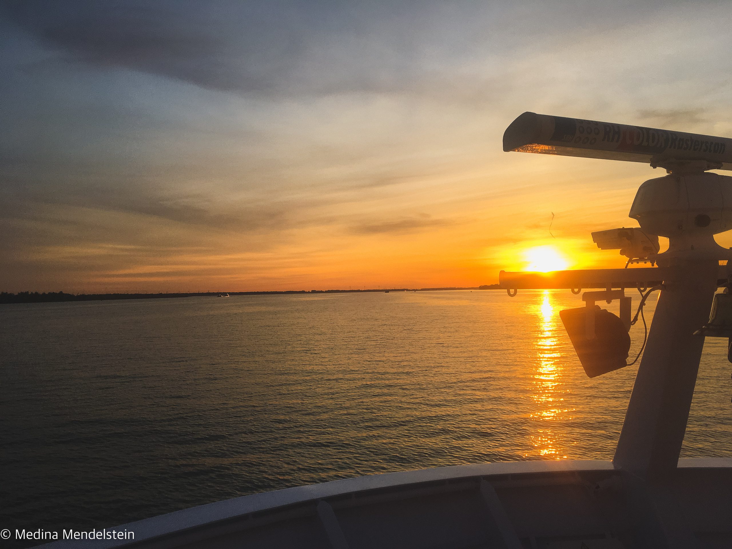 Schifffahrt: Zu sehen ist ein Sonnenuntergang auf dem Wasser, am rechten Rand ist das Radar von einem Flusskreuzfahrtschiff zu sehen.